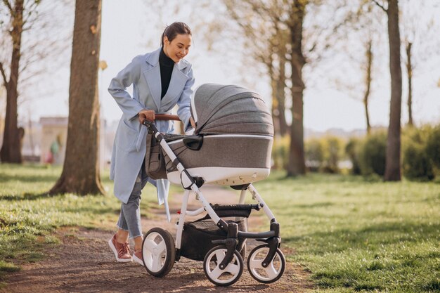 Jeune, mère, marche, voiture bébé, dans parc