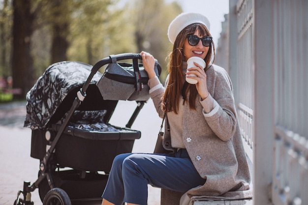 Jeune, mère, marche, voiture bébé, dans parc