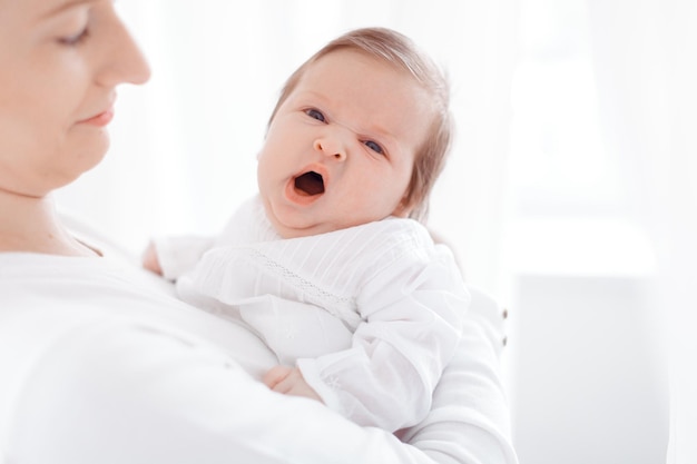 Jeune mère et nouveau-né dans une chambre blanche