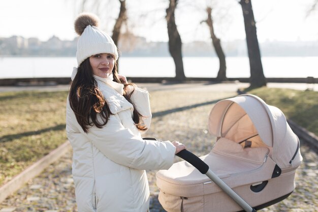 Jeune mère avec une poussette dans le parc
