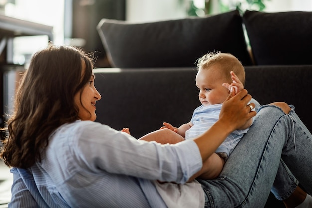 Photo gratuite jeune mère s'amusant avec son bébé dans le salon