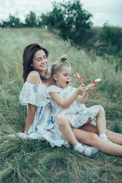 La jeune mère et sa fille sur l'espace d'herbe verte