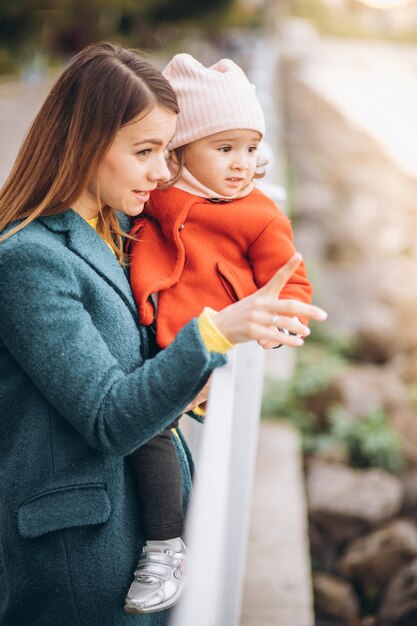 Jeune mère avec sa petite fille dans un parc d'automne