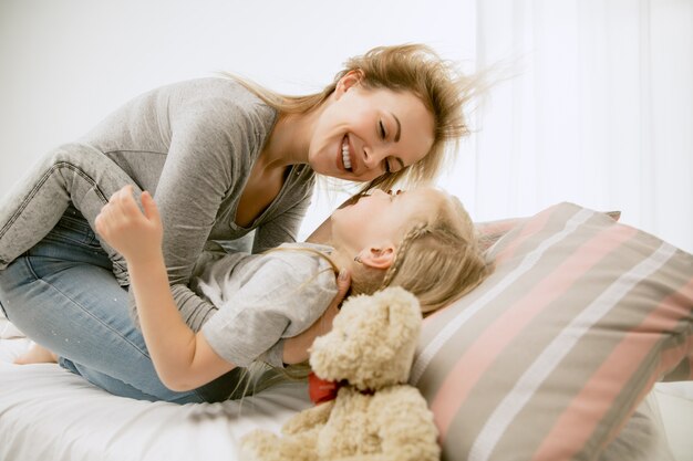 Jeune mère et sa petite fille à la maison au matin ensoleillé