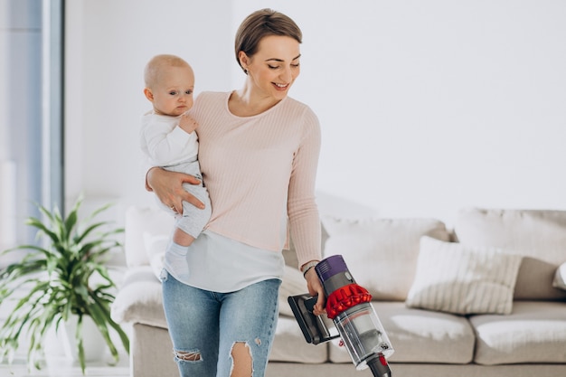 Jeune mère avec son petit garçon nettoyant à la maison