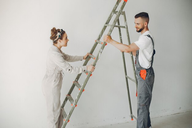 Le jeune et mignon couple répare la pièce