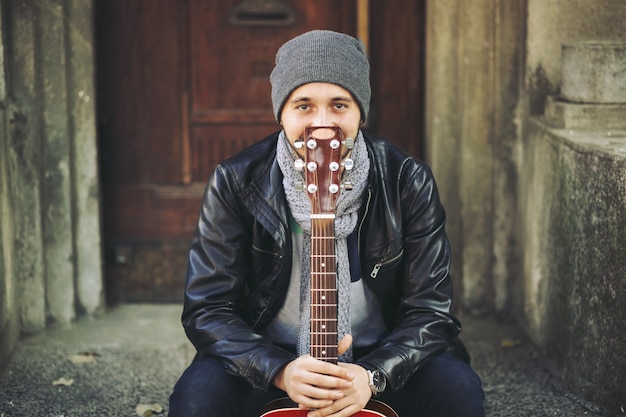 Jeune musicien avec guitare en ville