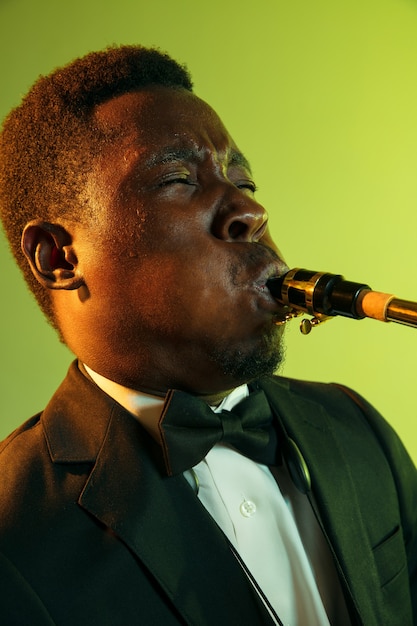 Photo gratuite jeune musicien de jazz afro-américain jouant du saxophone