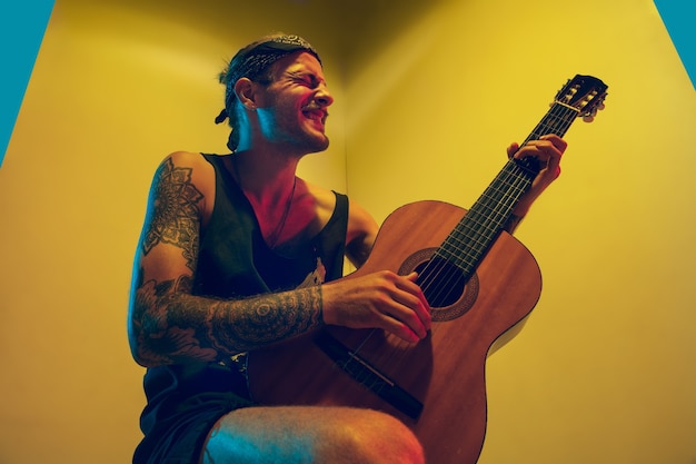 Jeune musicien sur un mur coloré en néon