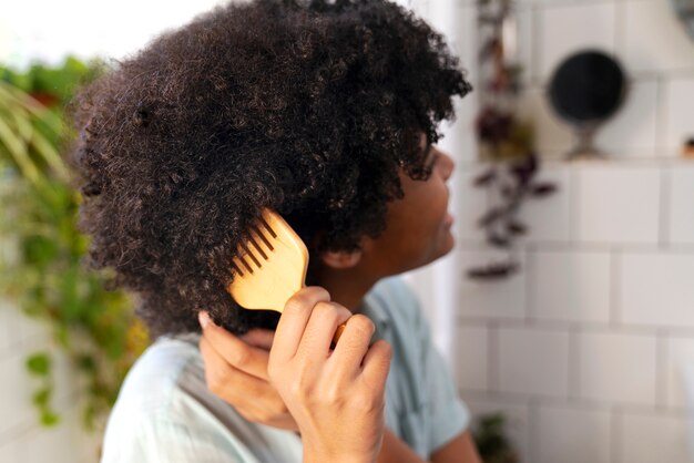 Jeune noir prenant soin des cheveux afro