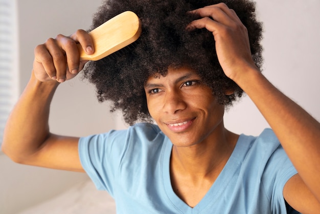 Photo gratuite jeune noir prenant soin des cheveux afro