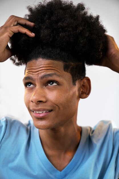 Jeune noir prenant soin des cheveux afro