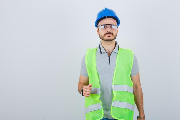 Jeune ouvrier du bâtiment dans un casque de sécurité et des lunettes