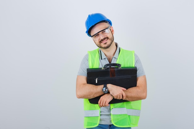 Jeune ouvrier du bâtiment dans un casque de sécurité et des lunettes
