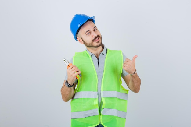 Photo gratuite jeune ouvrier du bâtiment portant un casque de sécurité