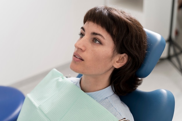 Photo gratuite jeune patiente en attente d'une procédure dentaire chez le dentiste