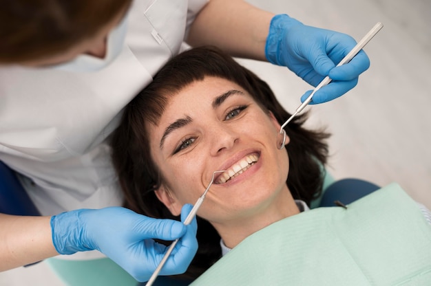 Photo gratuite jeune patiente ayant une procédure dentaire chez l'orthodontiste