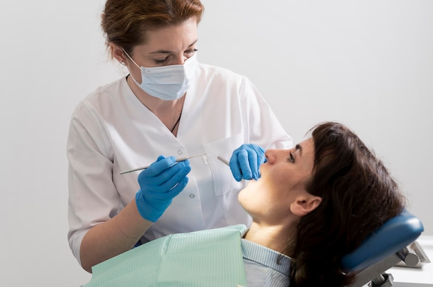 Photo gratuite jeune patiente ayant une procédure dentaire chez l'orthodontiste