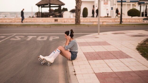 Jeune, patineur, séance, sur, trottoir, écoute, musique, sur, casque