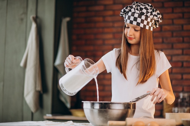 Jeune petite fille, pâtisserie à la cuisine pour le petit déjeuner