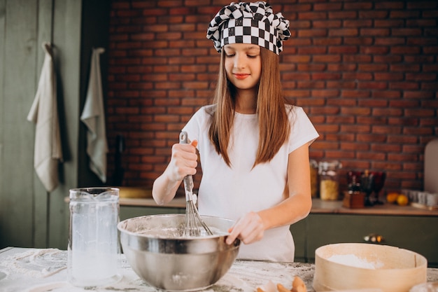 Jeune petite fille, pâtisserie à la cuisine pour le petit déjeuner