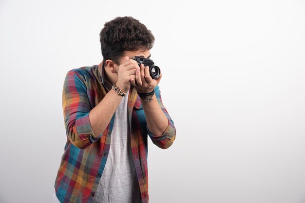 Jeune photographe expérimenté prenant des photos professionnelles de manière sérieuse.