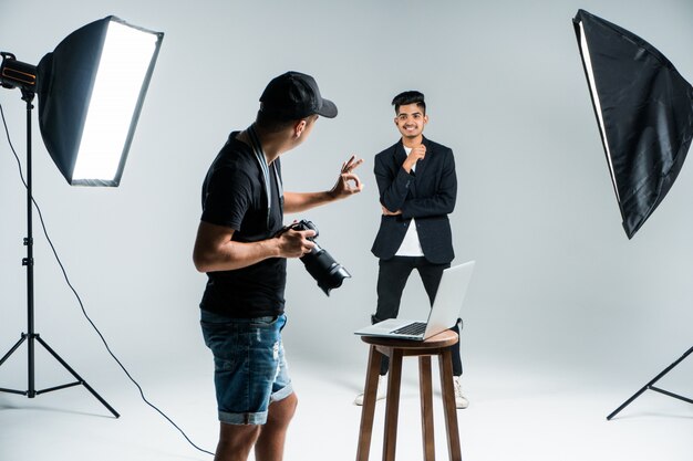 Jeune photographe professionnel à prendre des photos de modèle indien en studio avec leight