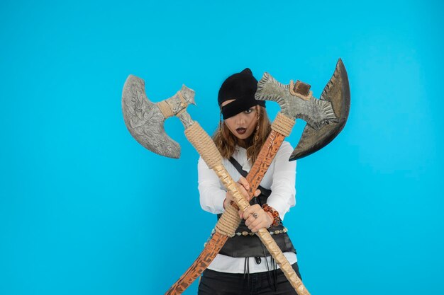 Jeune pirate confiant tenant des haches et regardant la caméra. Photo de haute qualité