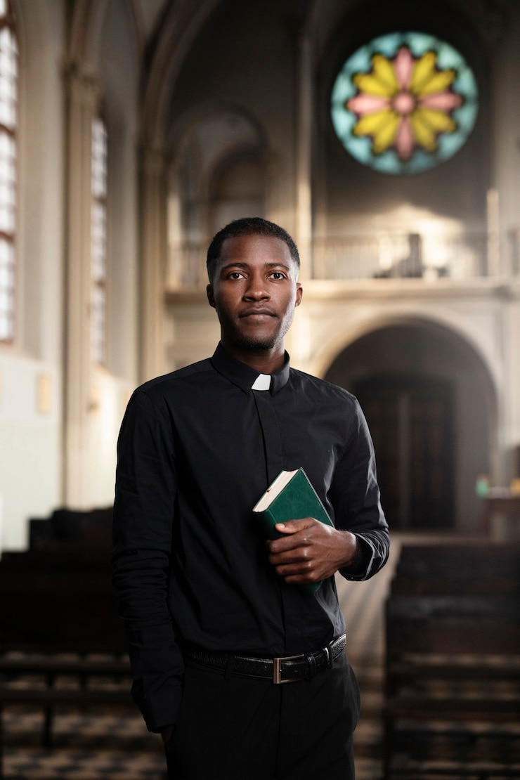 Photo gratuit jeune prêtre masculin tenant le livre saint dans l'église