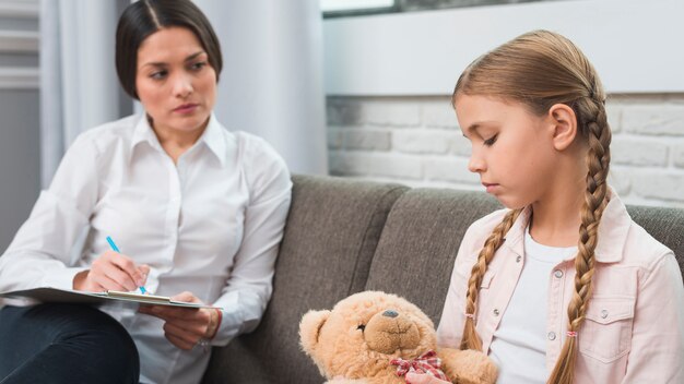 Jeune psychologue professionnelle essayant de toucher une fille avec des problèmes