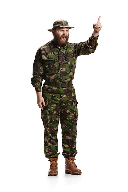 Jeune soldat de l'armée furieux en colère portant l'uniforme de camouflage isolé sur blanc studio