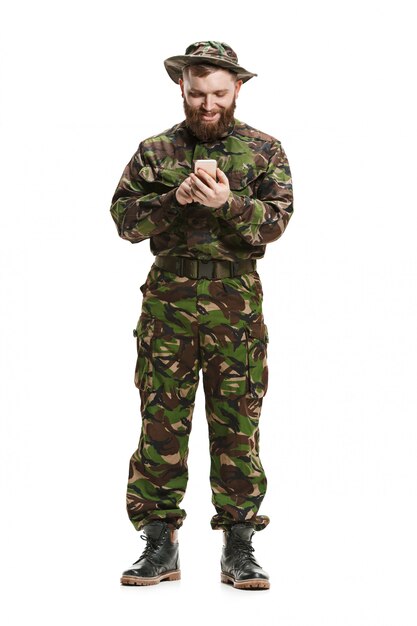 Jeune soldat de l'armée portant l'uniforme de camouflage isolé sur blanc