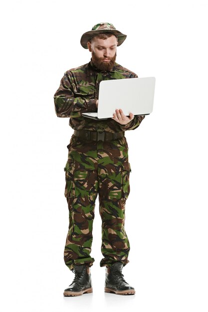 Jeune soldat de l'armée portant l'uniforme de camouflage isolé sur blanc