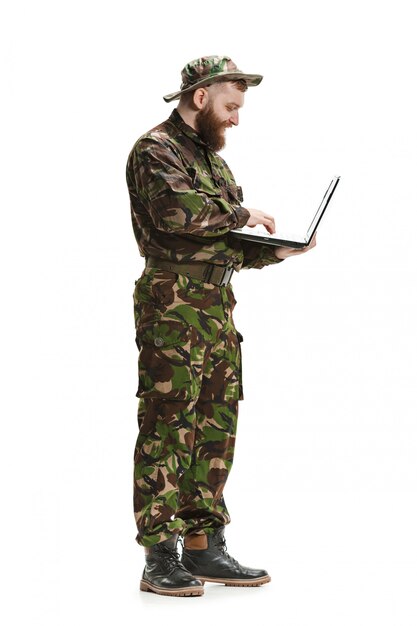 Jeune soldat de l'armée portant l'uniforme de camouflage isolé sur studio blanc