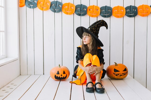 Jeune sorcière d&#39;Halloween en vedette à la fenêtre