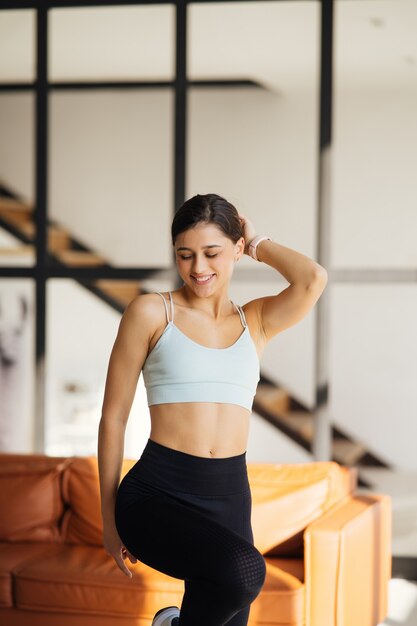 Jeune sportive détendue vêtue de vêtements de sport posant