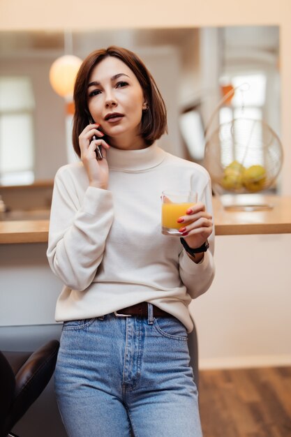 Jeune, tendre, dame, blanc, t-shirt, bleu, jean, cuisine, conversation, téléphone