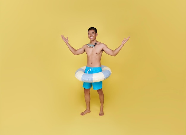 Un jeune touriste asiatique tient une bague gonflable pour des vacances d'été.