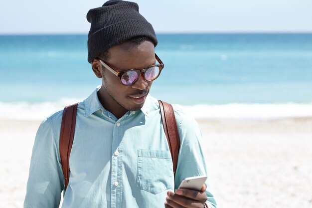 Jeune touriste à la mode affichant des photos via les médias sociaux