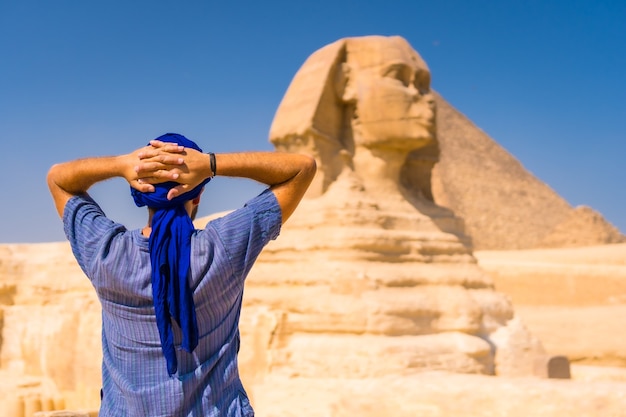 Jeune touriste portant un turban bleu debout près du Grand Sphinx de Gizeh, Le Caire, Egypte