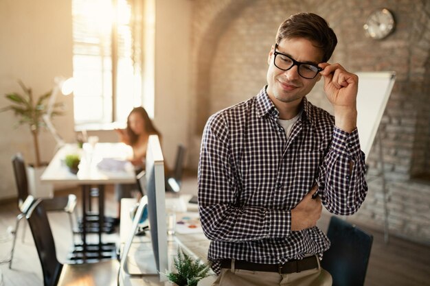 Jeune travailleur indépendant portant des lunettes tout en travaillant au bureau