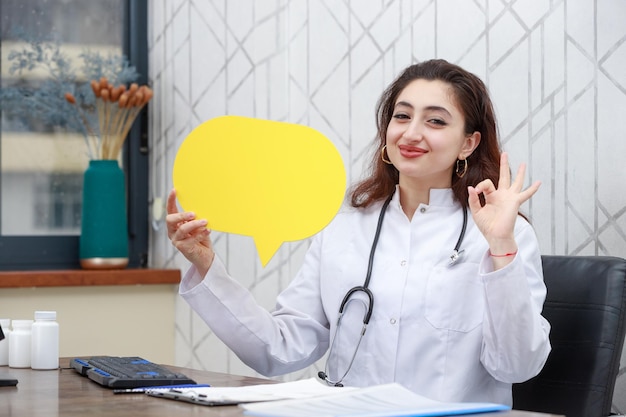 Jeune travailleur de la santé tenant une bulle d'idée et un geste OK Photo de haute qualité