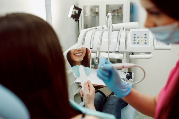 Jeune vérifier son sourire patient,