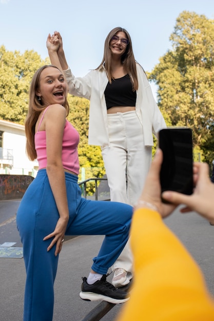 Jeunes adolescentes enregistrant des bobines d'elles-mêmes à l'extérieur pour les médias sociaux