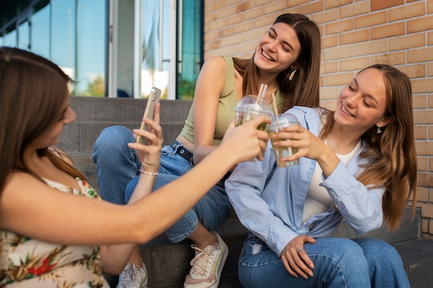 Photo gratuite jeunes adolescentes enregistrant des bobines d'elles-mêmes à l'extérieur pour les médias sociaux