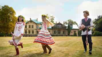 Photo gratuite jeunes adultes s'amusant en dansant folklorique