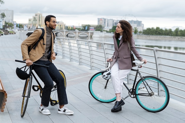 Photo gratuite jeunes adultes à vélo pour aller travailler en ville