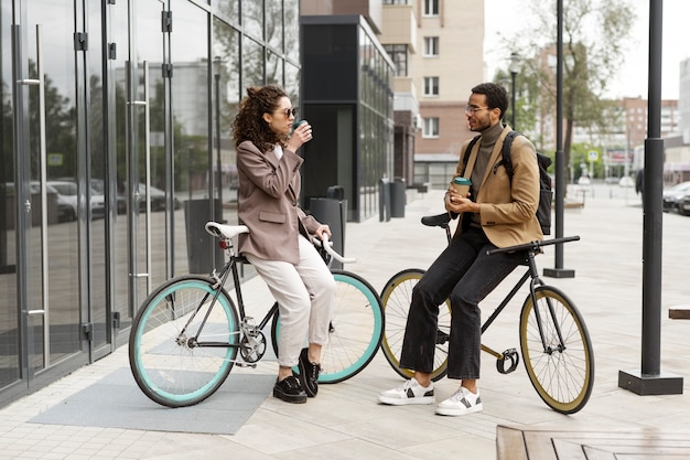 Photo gratuite jeunes adultes à vélo pour aller travailler en ville