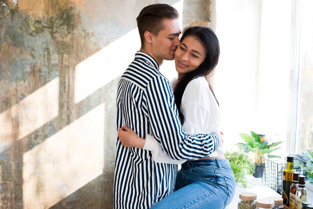 Jeunes amants heureux calins doucement dans la cuisine