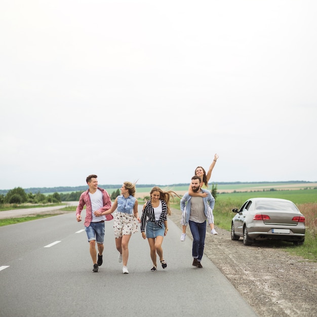 Jeunes amis appréciant ensemble sur la route de campagne